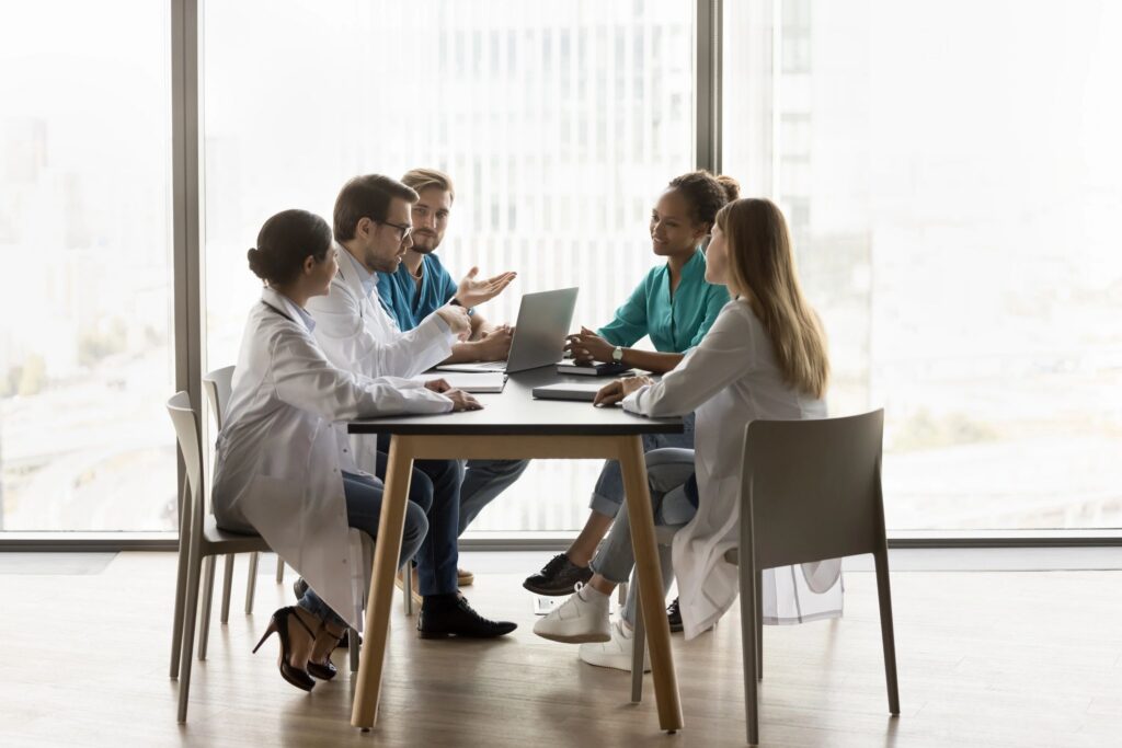 Diverse team of hospital doctors meeting at table